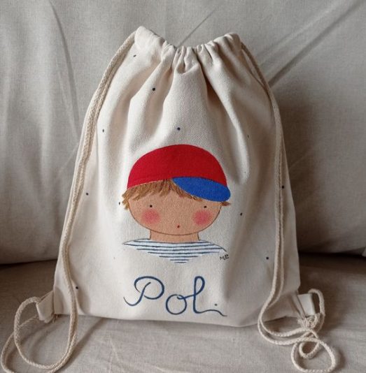 Mochila saco infantil de tela con diseño personalizado y nombre pintado a mano para niño.